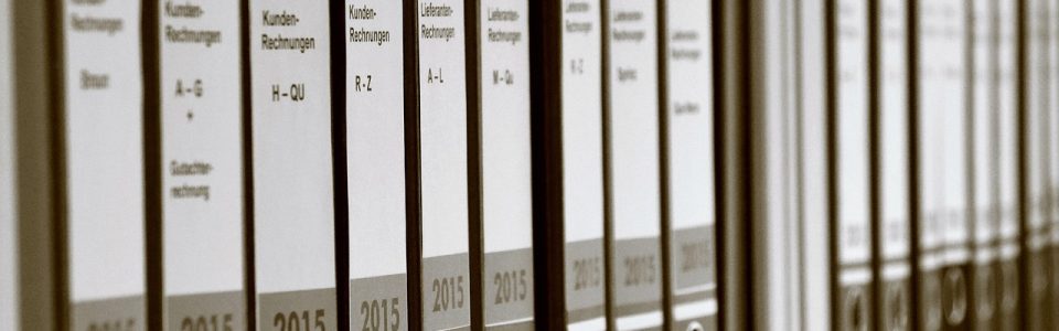 Archivadores organizados con documentos de empresa en estantería