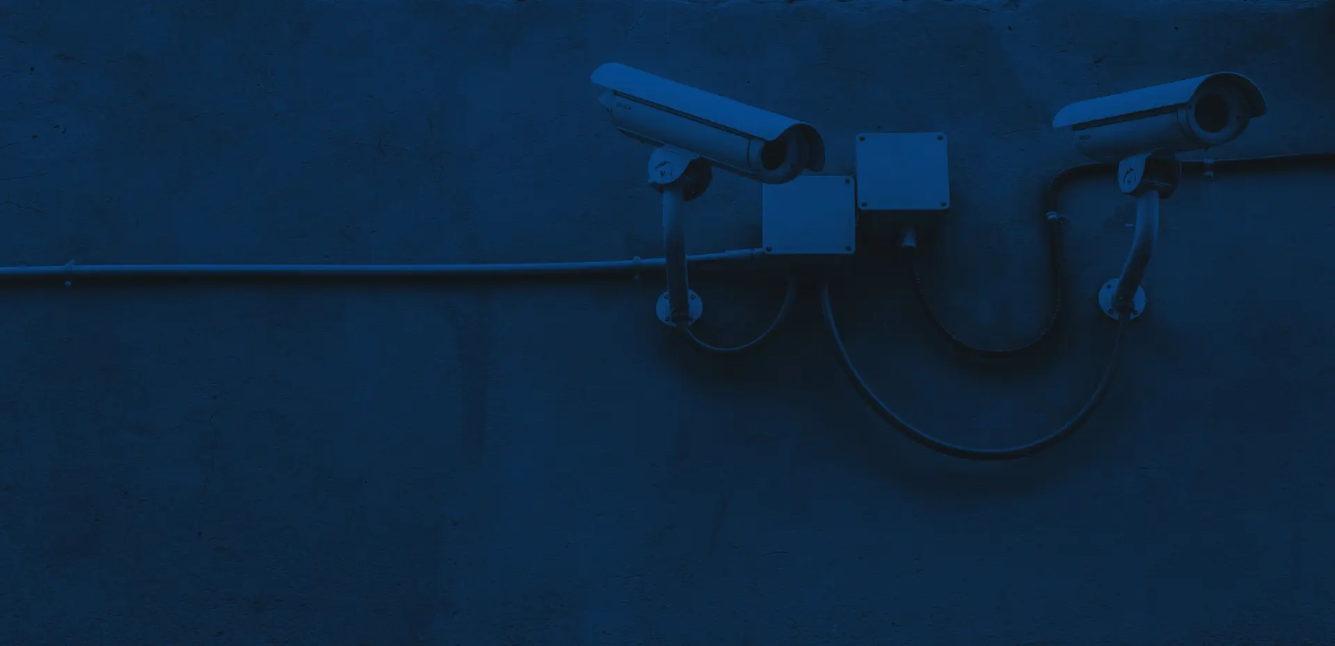 Boudi seguridad Cámaras de vigilancia sobre una pared azul como representación de la seguridad y protección de la información en boudi.